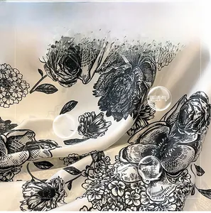 Detailed view of floral silk scarf fabric texture with elegant black and white print