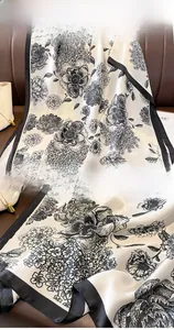 Macro detail of retro floral silk scarf with black satin edges and smooth texture