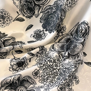 Detail of silk-like floral scarf fabric with retro black and white rose patterns