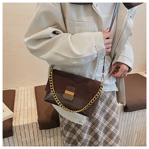 Détail du sac à bandoulière en daim rétro marron avec chaîne dorée et fermoir métal