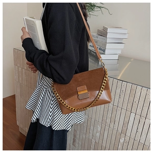 Détail du sac à main vintage en daim avec bandoulière chaîne dorée et fermoir en métal