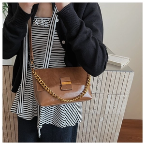Détails du sac bandoulière vintage marron avec patchwork en daim et chaîne dorée