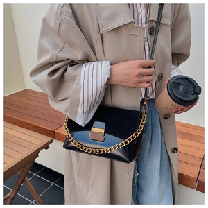 Détail du sac à bandoulière vintage en daim avec chaîne dorée et boucle métallique