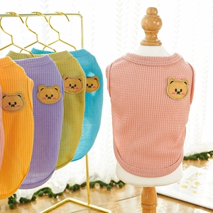 Detail of dog waffle vests in pastel colors featuring a brown bear embroidery patch