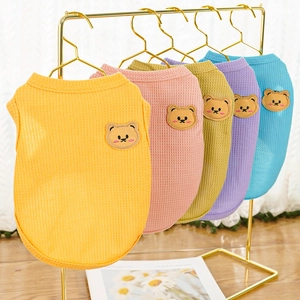 Detailed view of dog waffle vests in five colors hanging on gold hangers