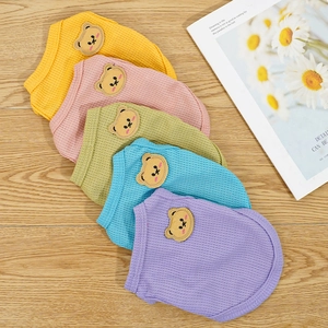 Flat lay of colorful waffle knit pet t-shirts featuring cute bear embroidery and bright colors