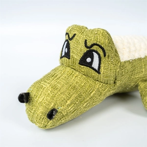 Close-up of green canvas plush pet toy with white textured fabric and cute embroidered eyes