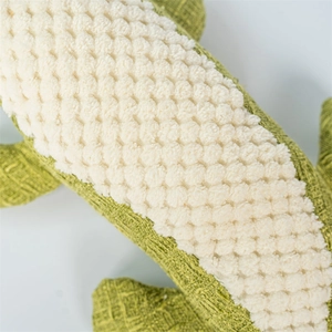 Detail of plush dog toy featuring cross-textured green fabric and white nubby fleece