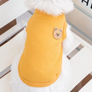 Detail of yellow waffle knit dog vest featuring a cute brown bear patch on back