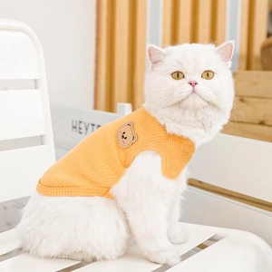Detail of ginger yellow waffle knit pet vest featuring a cute brown bear embroidery patch