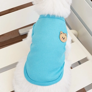 Detail of light blue waffle knit pet vest featuring a cute brown bear embroidery patch