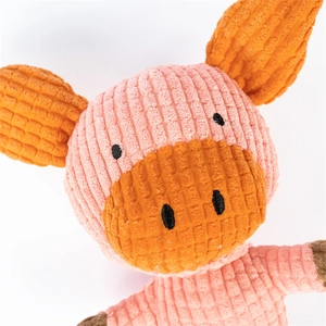 Detail of pink corduroy plush dog toy showing striped texture and embroidered pig face