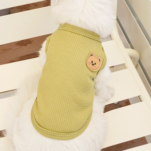 Detail view of grass green waffle fabric pet vest with cute bear embroidery on dog
