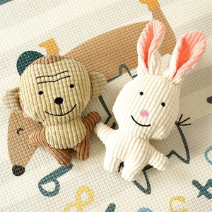 Corduroy plush monkey and rabbit chew toys for pets and infants on a play mat