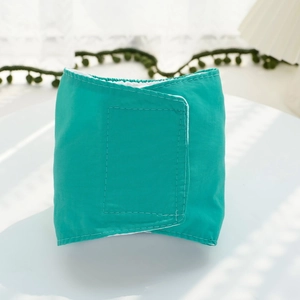 Detailed view of mint green dog belly band with velcro closure and soft white lining