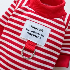 Detail of red and white striped pet sweater with integrated metal D-ring for leash attachment