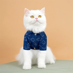 Detailopname van een blauw denim huisdieroverhemd met berenprints op een witte kat