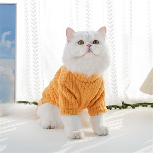 Close-up of thick knitted dog sweater with waffle texture on a white long-haired cat