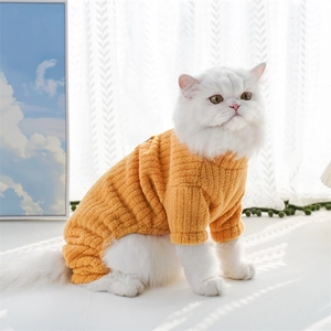 Close-up of thick ginger yellow ribbed knit sweater on a white long-haired cat