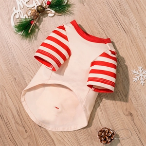 Detail of cream dog shirt with red striped sleeves and Christmas festive decorations