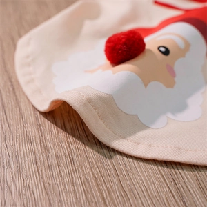 Close-up of beige knit pet bib featuring a Santa Claus motif and 3D red pom-pom nose