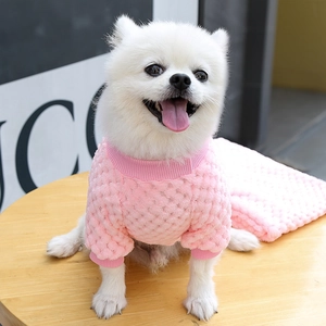 Dettaglio della trama in maglia rosa a palline e bordi a costine sul maglione per cani