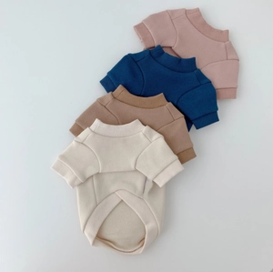 Flat lay of colorful knitted pet sweaters in pink blue brown and beige with ribbed cuffs