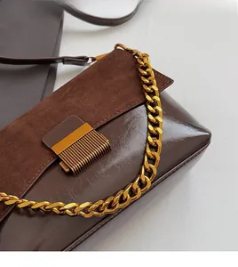 Détail du sac marron en similicuir et suède avec chaîne dorée et fermoir