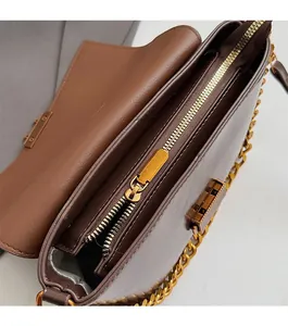 Gros plan sur la fermeture éclair dorée et la doublure intérieure du sac marron