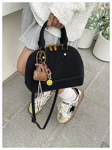 Dettaglio borsa a conchiglia nera con zip dorate e sneaker argento metallizzato alla moda