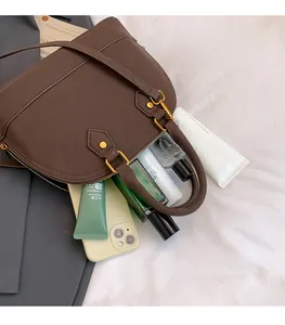 Dettaglio dell'ampio interno della borsa a tracolla vintage marrone con oggetti di uso comune