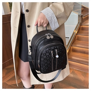Detail of black checkered PU leather backpack with silver zippers and multi-pocket design