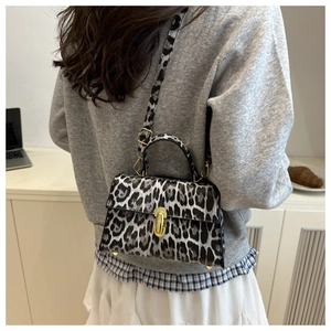 Detail of leopard print crossbody bag featuring gold metal turn-lock and sturdy top handle