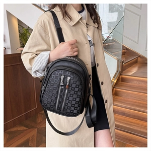 Detail of black pebbled leather backpack with silver zippers and checkerboard print