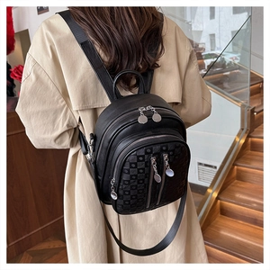 Close-up of black pebble leather backpack with checkered patterns and silver metal charms