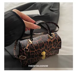 Détail d'un sac à main léopard avec fermoir rotatif doré et texture en cuir synthétique PU