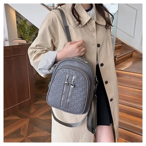 Detail of grey PU leather backpack with embossed plaid and multiple zipper pockets