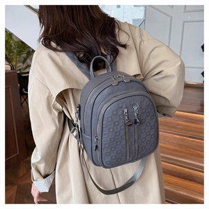 Macro view of grey PU leather backpack featuring geometric embossed patterns and metal zippers