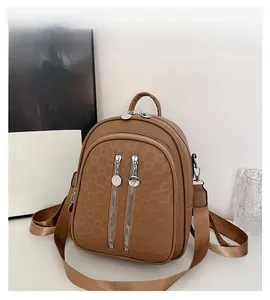 Detail of brown embossed checkered pattern and silver zippers on a versatile backpack