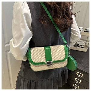 Detail of green and white patchwork crossbody bag with metallic lock and round coin purse