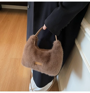 Detail of plush brown tote bag featuring metal handle and premium faux fur texture