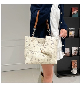 Detail view of large cream tote bag with YADIER lettering and matching small pouch