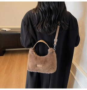 Detail of plush brown tote bag featuring leather handles and 'Love every day' patch