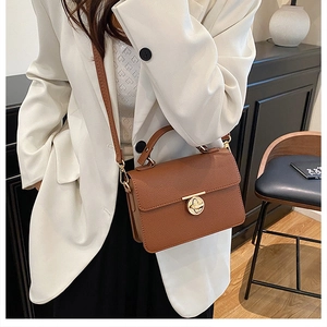 Side view of caramel brown pebbled leather crossbody bag with golden ring turn-lock detail