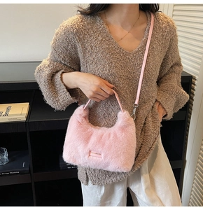 Close-up of pink faux fur crescent bag with love every day tag and leather handle