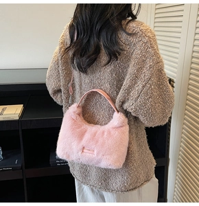 Detail of pink plush crossbody bag featuring 'love every day' patch and soft faux fur