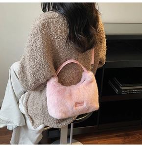 Detailed shot of pink plush handbag with love every day tag and metal strap buckles