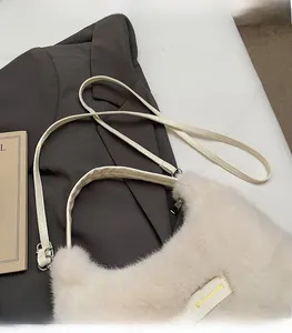 Detail of plush off-white shoulder bag with adjustable strap and love every day tag