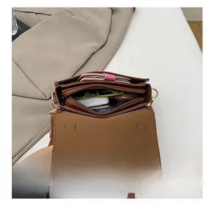 Top view of brown lychee texture crossbody bag interior showing multiple compartments