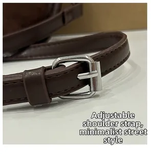 Détail de la bandoulière réglable en similicuir marron foncé avec boucle en métal argenté